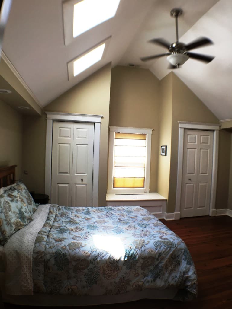 A vaulted bedroom — skylights, window seat, and two closets
