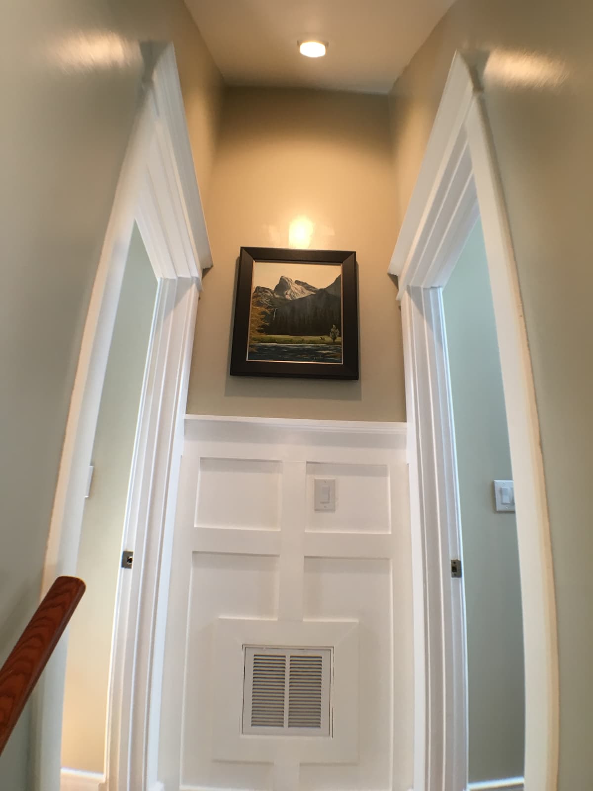 The upstairs landing's paneled wall and framed art