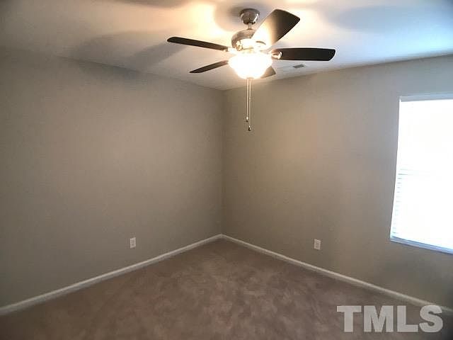 A carpeted bedroom with ceiling fan