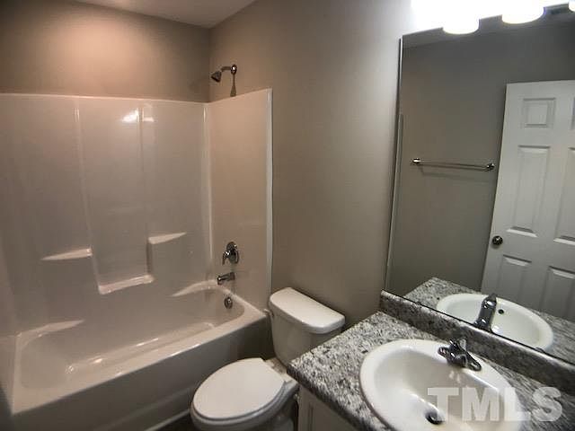 The bathroom — shower-tub and granite-look vanity